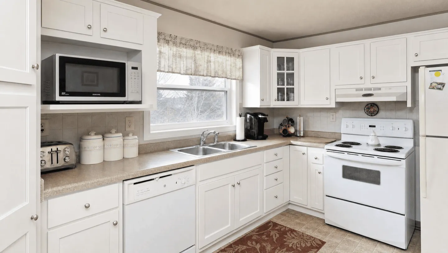 Same cabinets after refinishing — soft white shaker, factory-smooth